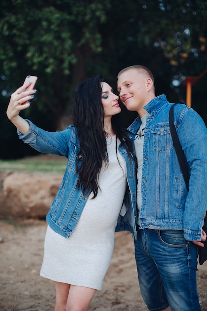 Lovely couple walking in park and taking selfie together