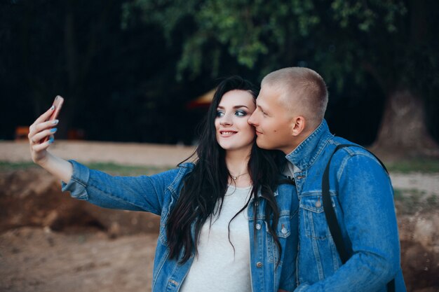 Lovely couple walking in park and taking selfie together