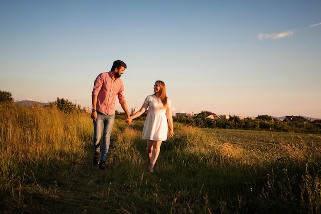 Lovely couple walking in the summer field