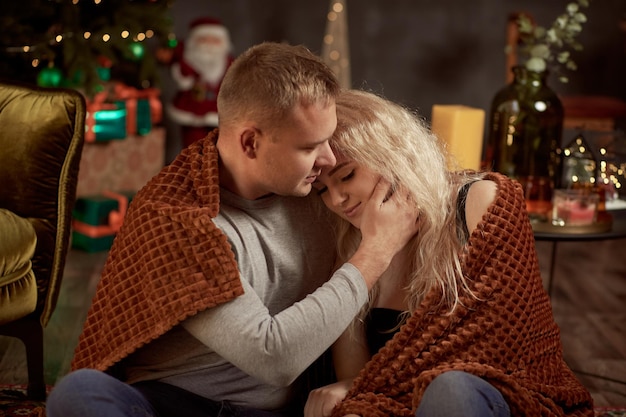 Lovely couple of wife and husband in aesthetic cozy home interior with festive Christmas tree Candid true moment Good mood and having fun together Christmas love story