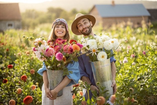 Lovely couple with dahlia flowers at garden outdoors