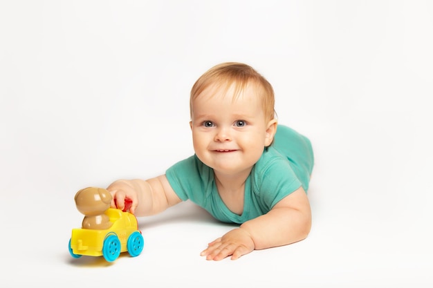 Lovely cute baby boy rolling a toy car on the floor child playing with toy train childhood kids and ...