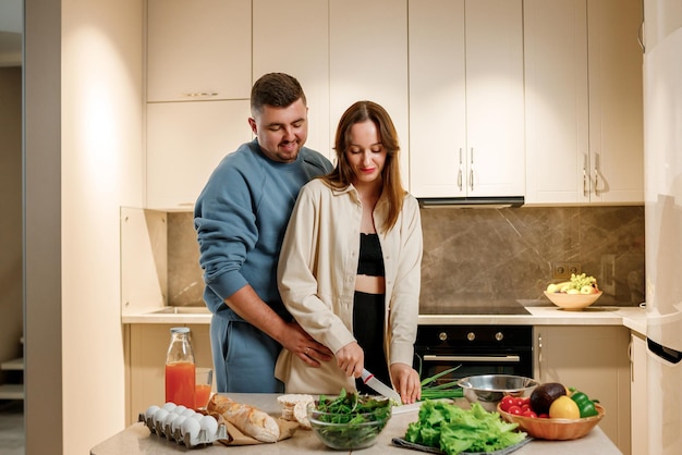 Lovely family couple preparing vegetable vegan salad together in kitchen Healthy food and diet concept lifestyle Cook at home