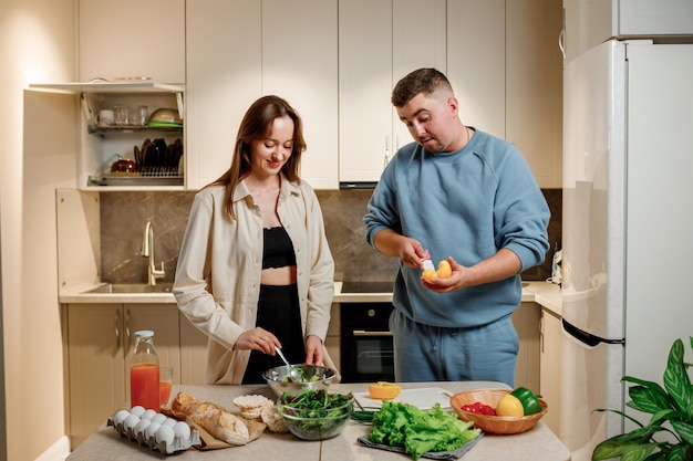 Lovely family couple preparing vegetable vegan salad together in kitchen Healthy food and diet concept lifestyle Cook at home