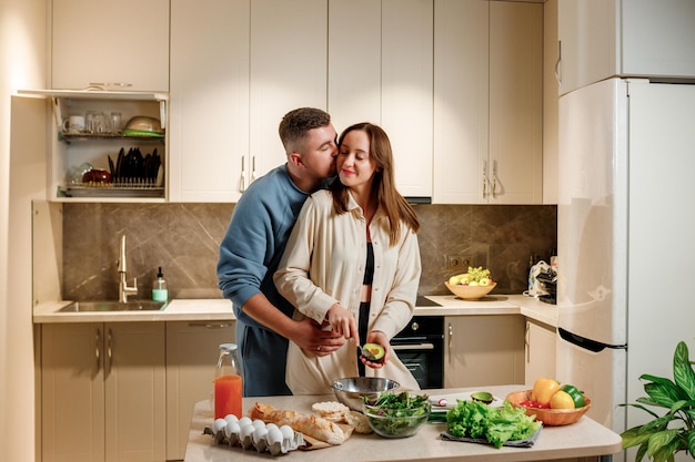 Lovely family couple preparing vegetable vegan salad together in kitchen Healthy food and diet concept lifestyle Cook at home