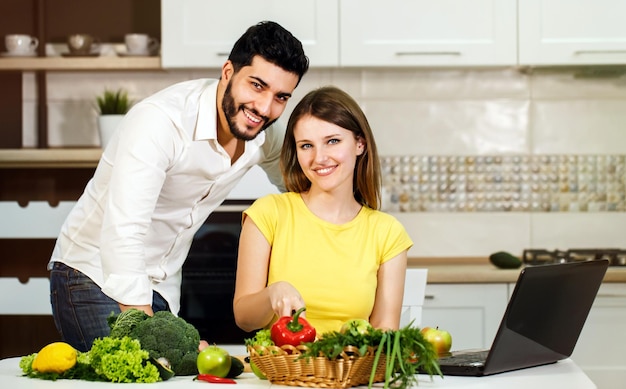 Lovely family couple spending evening together smiling woman slicing cucumber