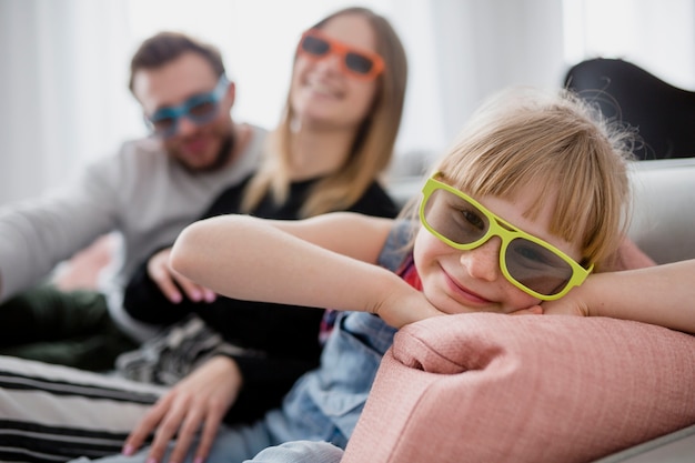 Lovely girl in 3D glasses near parents