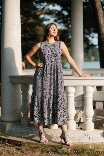 Lovely girl in grey summer dress on forest road