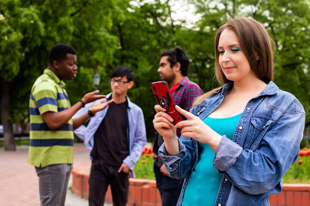 Lovely girl taking selfie during meeting with male friends