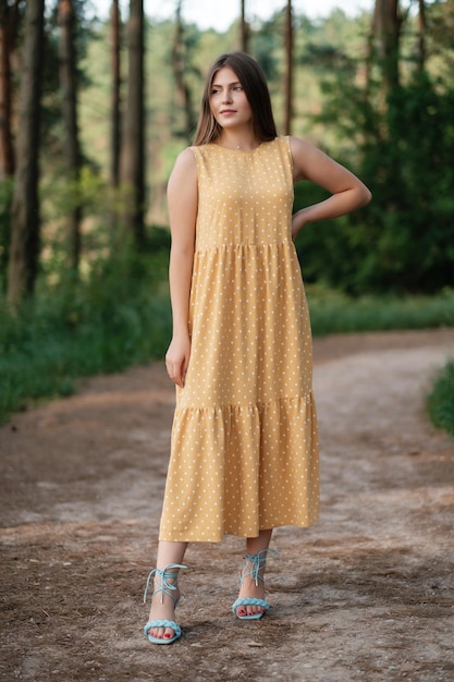 Lovely girl in yellow summer dress outdoors