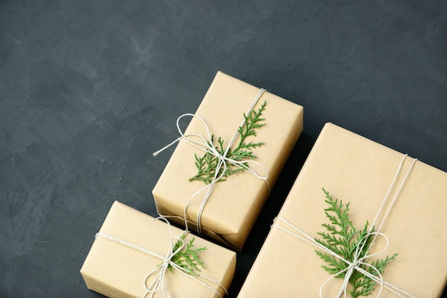 Photo lovely holiday wrapping ideas rustic eco christmas packages with brown paper, string and natural fir branches on dark background