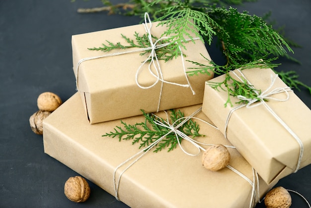 Photo lovely holiday wrapping ideas rustic eco christmas packages with brown paper, string and natural fir branches on dark background