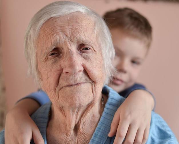 Lovely little boy with his grandmother having fun and happy moments together at home