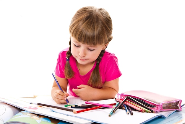 Lovely little girl writing at the desk