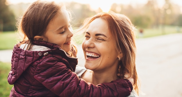 Lovely mother and her little girl laughing during a summer walk