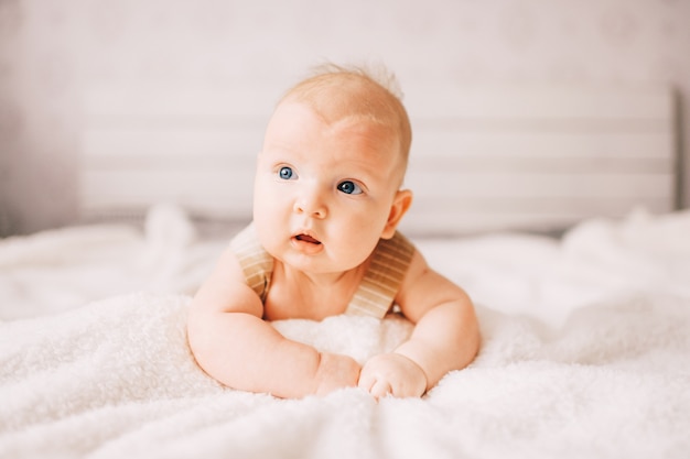 Lovely newborn lying on bed.