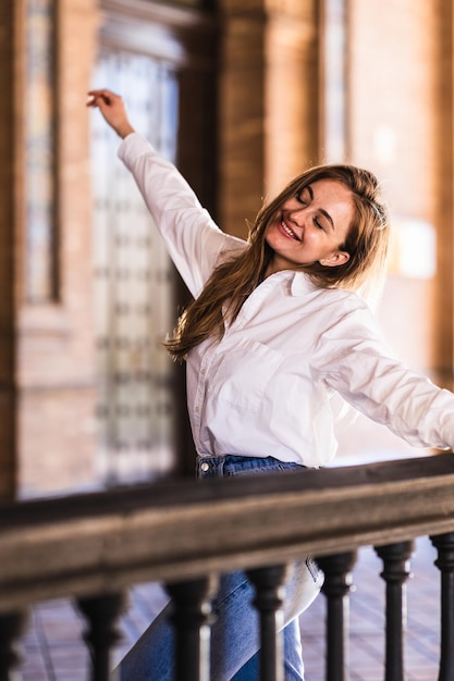 Lovely smiling caucasian woman dancing on a balcony in Plaza de Espana in Seville