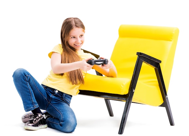 Lovely teen girl in yellow tshirt playing with joystick ona white background