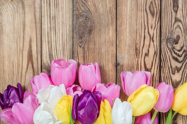 Lovely tulip flowers on wooden table, rustic design