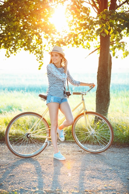 Lovely young woman in a hat riding a bicycle in a park Active people Outdoors