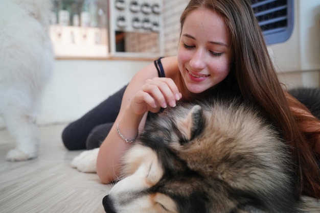 Lovely young woman playing with her dog