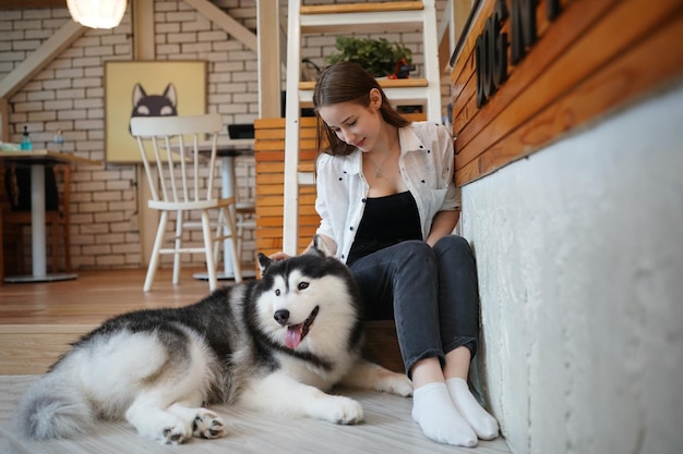 Lovely young woman playing with her dog