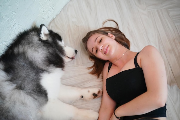 Lovely young woman playing with her dog