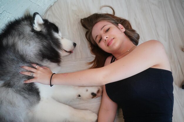 Lovely young woman playing with her dog