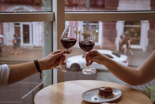 Lovers boy and girl hold glasses in their hands in a cafe