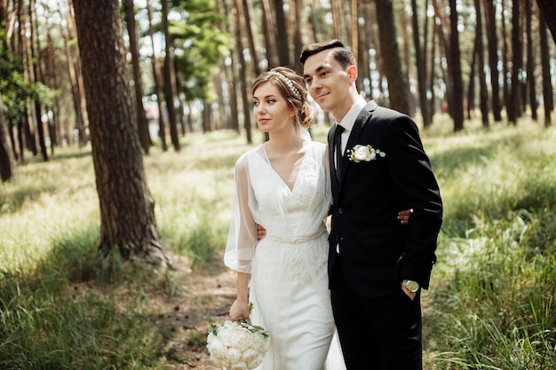 Lovers hug being in nature. the bride and groom are walking in the forest. wedding couple