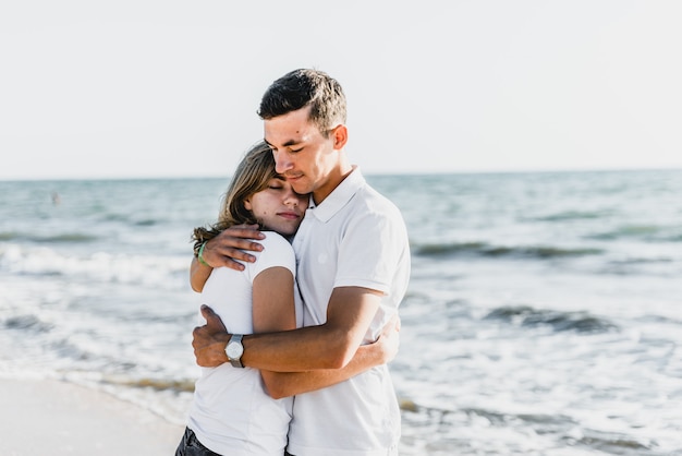 Lovers near the ocean hug and have fun. husband and wife hugs at sunset near the sea. lovers on vacation. summer rest. romantic walk by the ocean