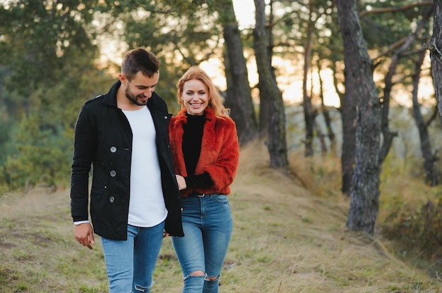 Lovers walking hand in hand in autumn park