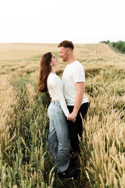 Lovers in a wheat field play and laugh. romantic relationship of a modern couple. lovers walk in nature.