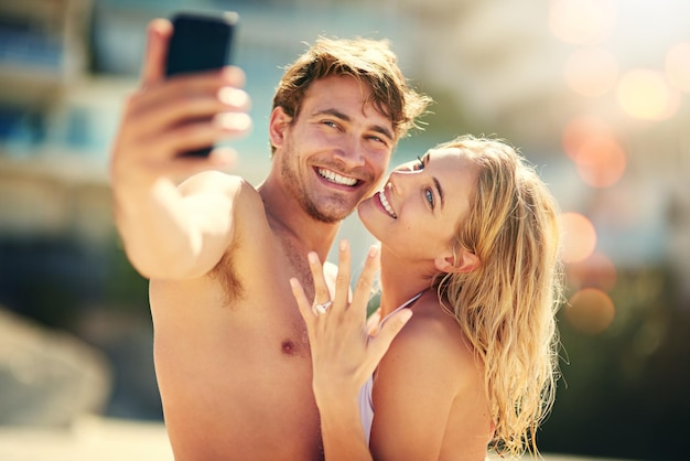 Lovin my wedding ring Cropped shot of a young woman showing off her wedding ring while taking a selfie with her husband