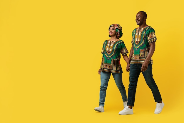 Loving african man and woman walking on yellow