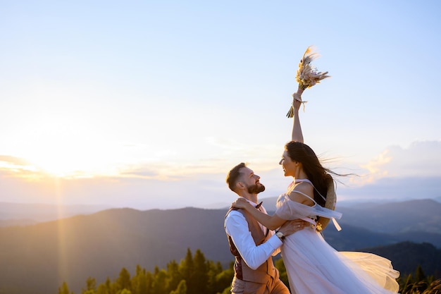 Loving bride in groom enjoying sunset in mountais