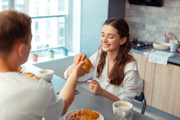 Loving caring husband giving apple to his appealing wife