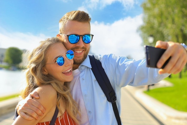 Loving cheerful happy couple taking selfie in the city