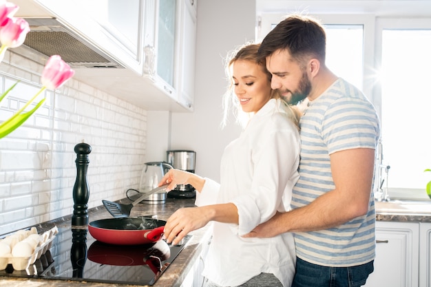 Loving Couple Cooking Breakfast in Kitchen