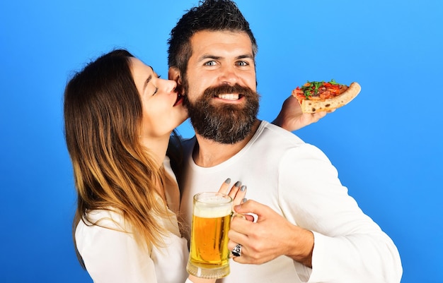 Loving couple eating yummy pizza drinking beer at pizzeria or pub happy family time fast food