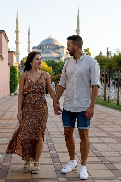 Loving couple gazing into each other39s eyes and holding hands with the Blue Mosque in the background in Istanbul Turkey