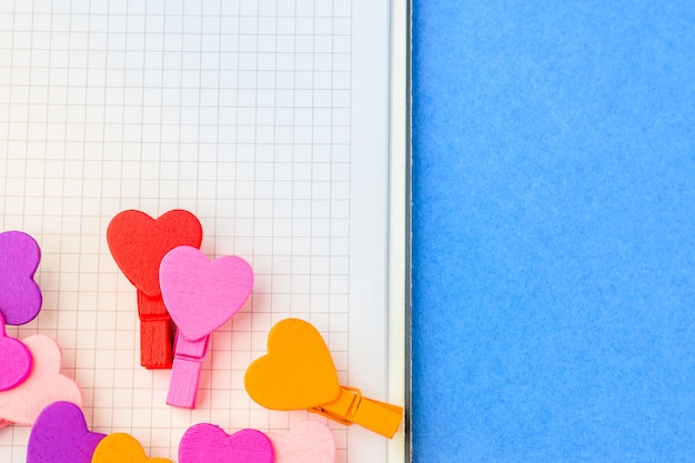 A loving couple of hearts on white paper on a blue background. 