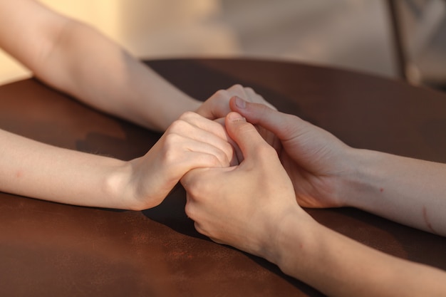 Loving couple holding hands on table in cafe