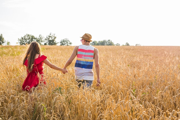 Loving couple holding hands while walking at sunset