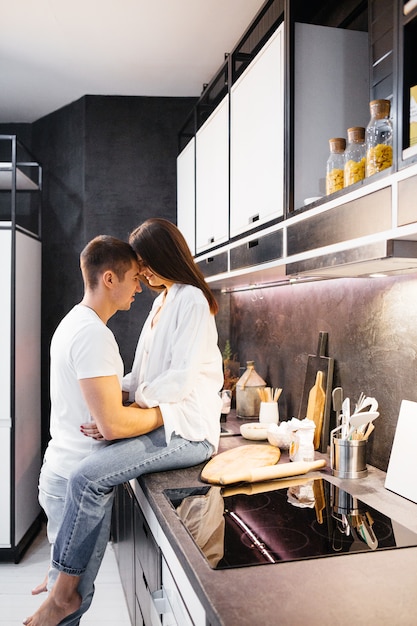 Loving couple in the kitchen. Man and woman kiss. Wife with husband, family relationship