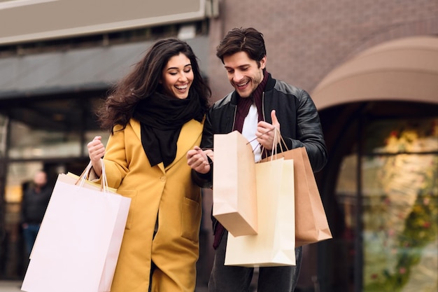 Loving couple looking into shopping bags outdoors