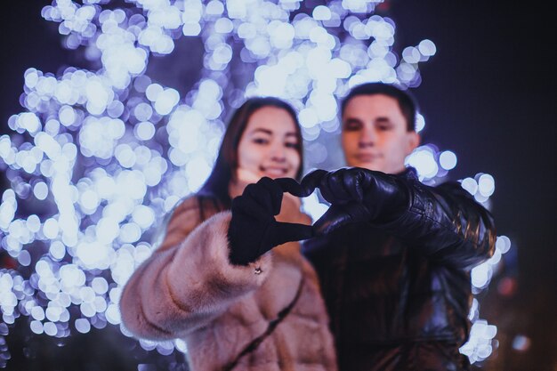 Loving couple near The Christmas tree in the night outdoor