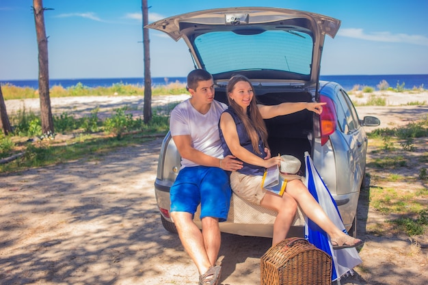 loving couple travel in a car Man and woman sitting in the trunk