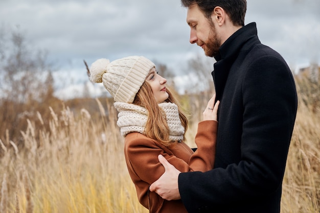 Loving couple walking in Park in autumn hugs and kisses. 