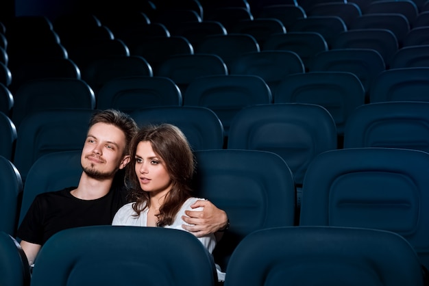 Loving couple watching a movie in the empty cinema